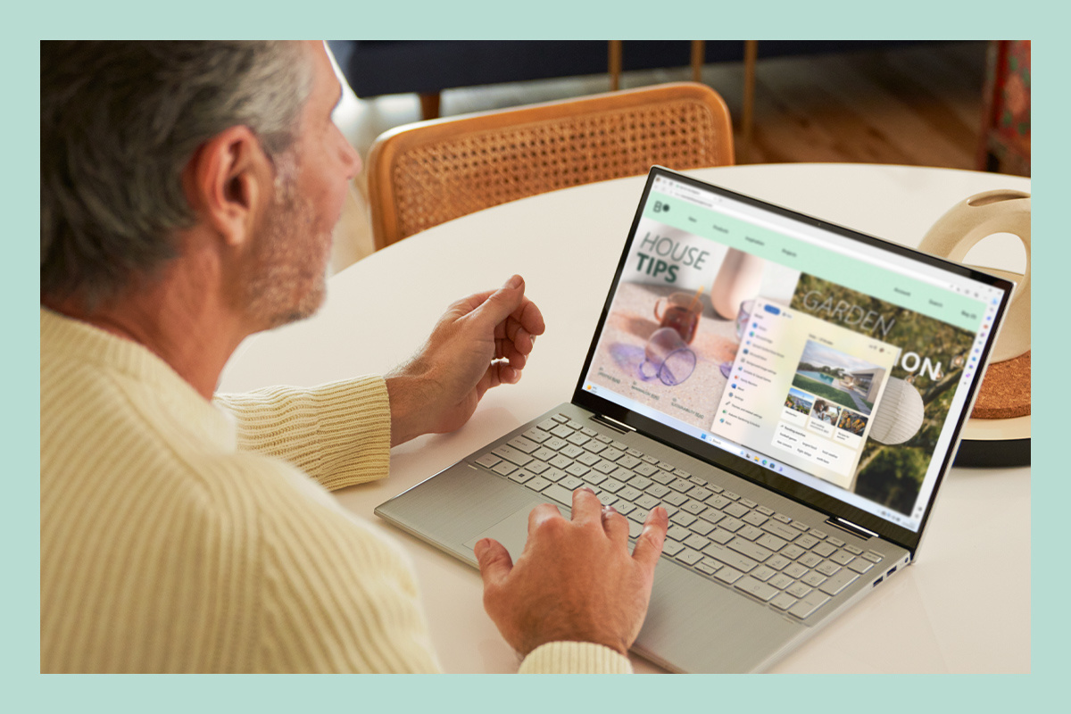Mies työskentelee kannettavalla tietokoneella, jossa on Windows 11.